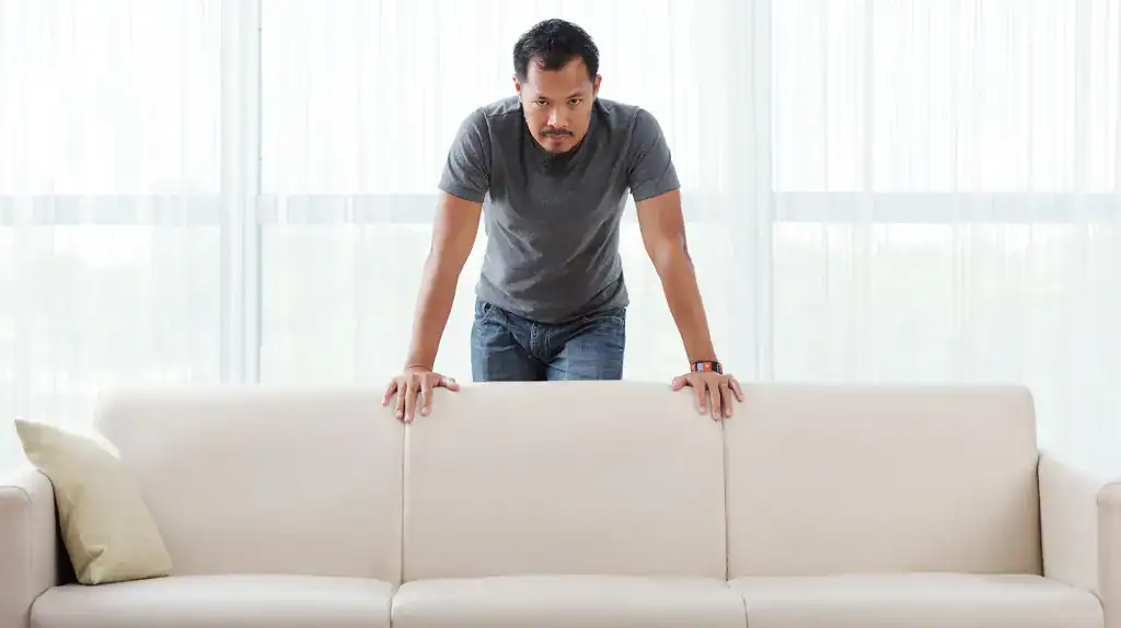 a man standing behind a couch